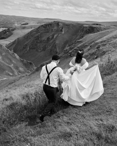 Wedding couple walking through Peak District countryside