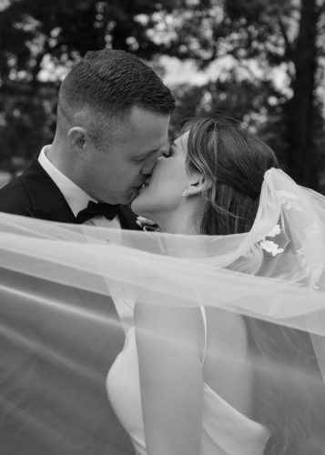 a wedding couple posing for a kiss 